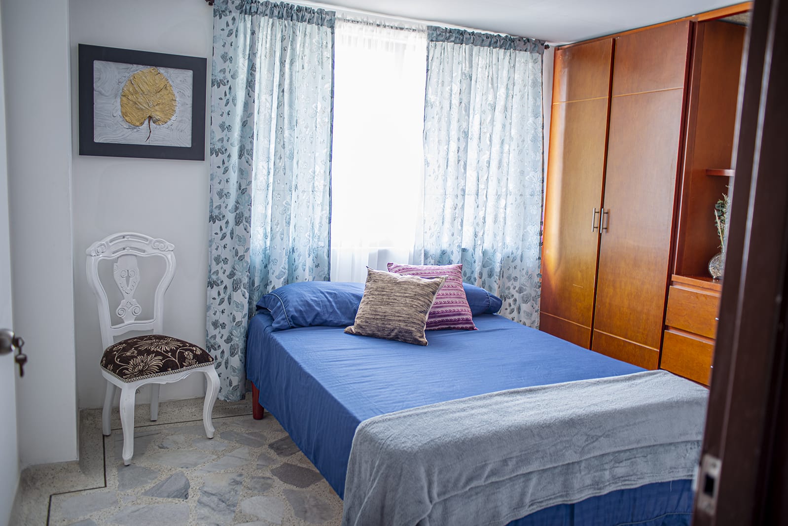 Blue bedroom with wardrobe and window